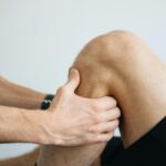 Detailed image of a physiotherapy session focusing on knee massage treatment.