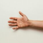An outstretched human hand with open palm isolated on a plain white background.