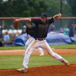 A baseball pitcher in a determined pose during a game outdoors.